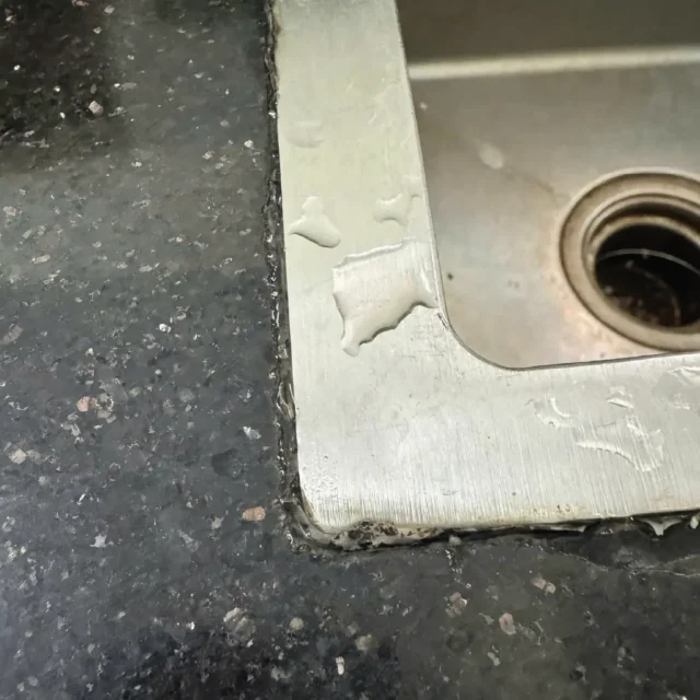 Rò rỉ nước qua lớp silicon bị lão hóa giữa mặt bàn đá và bồn rửa chén