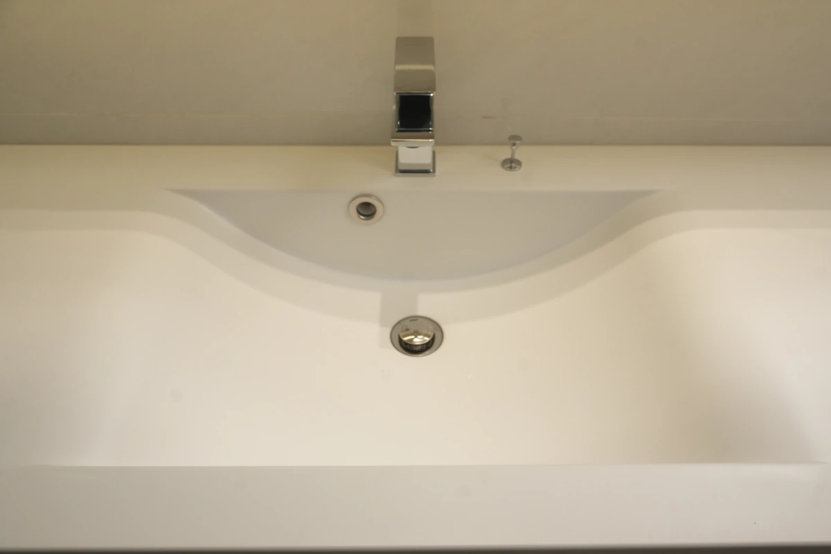 Lòng chậu lavabo liền khối TQ nhìn thẳng: thành chậu cong hai bên, lỗ xả và khe tràn liền mặt đá